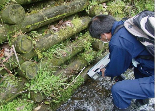 河川に設置した構造物の水にぬれている箇所の木材を調査している様子